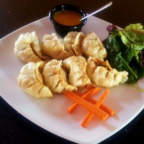 A plate of dumplings and salad, a delicious and healthy meal option.